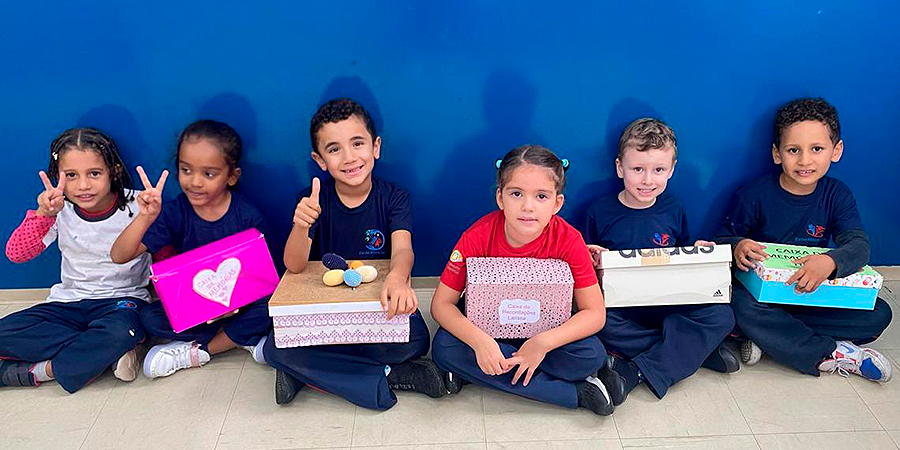 alunos segurando caixas de sapato com lembranças 
