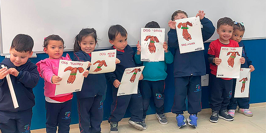 crianças segurando trabalho escolar 